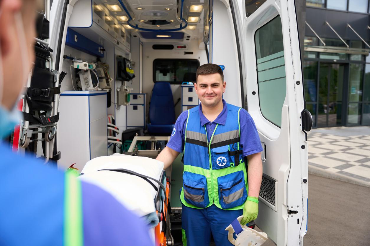 EMS paramedic moving a stretcher out of an ambulance